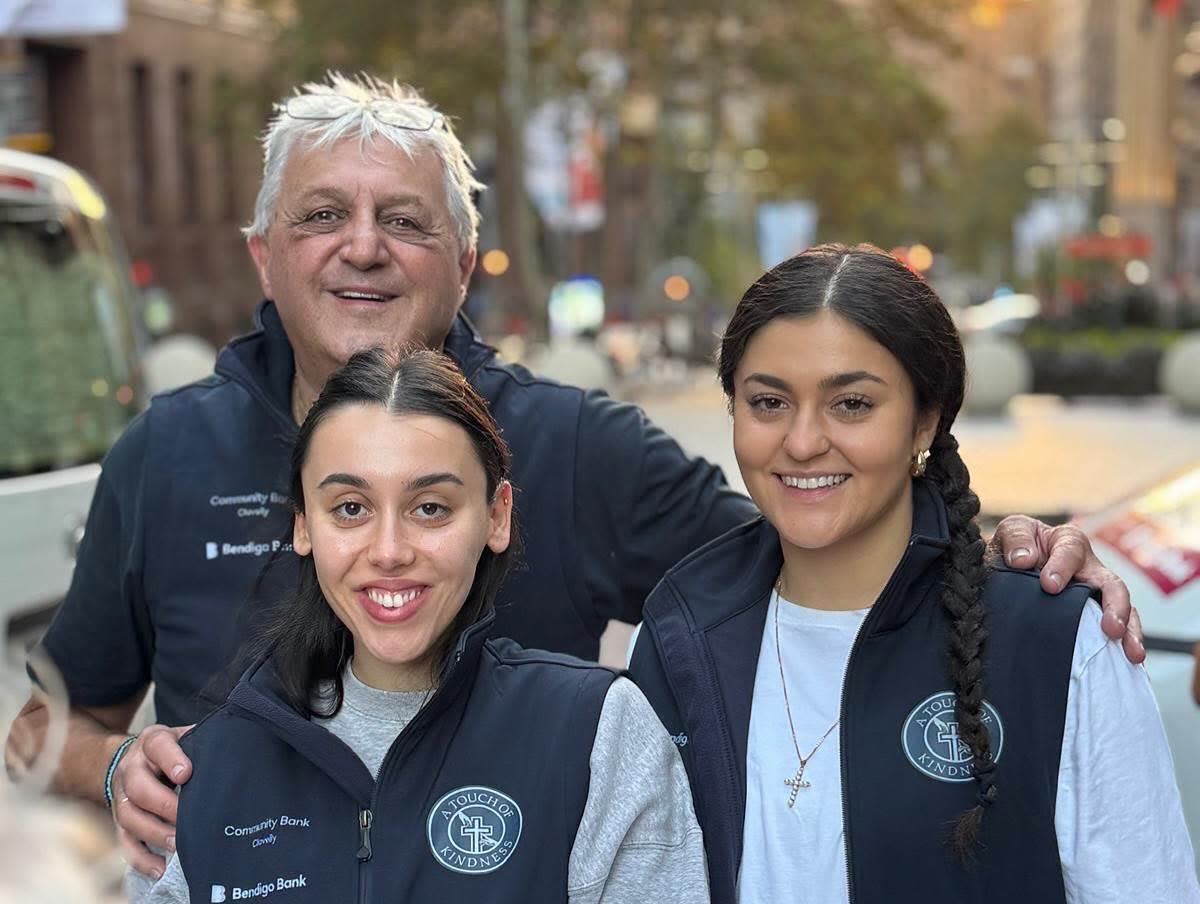 Three volunteers smiling together at Martin Place