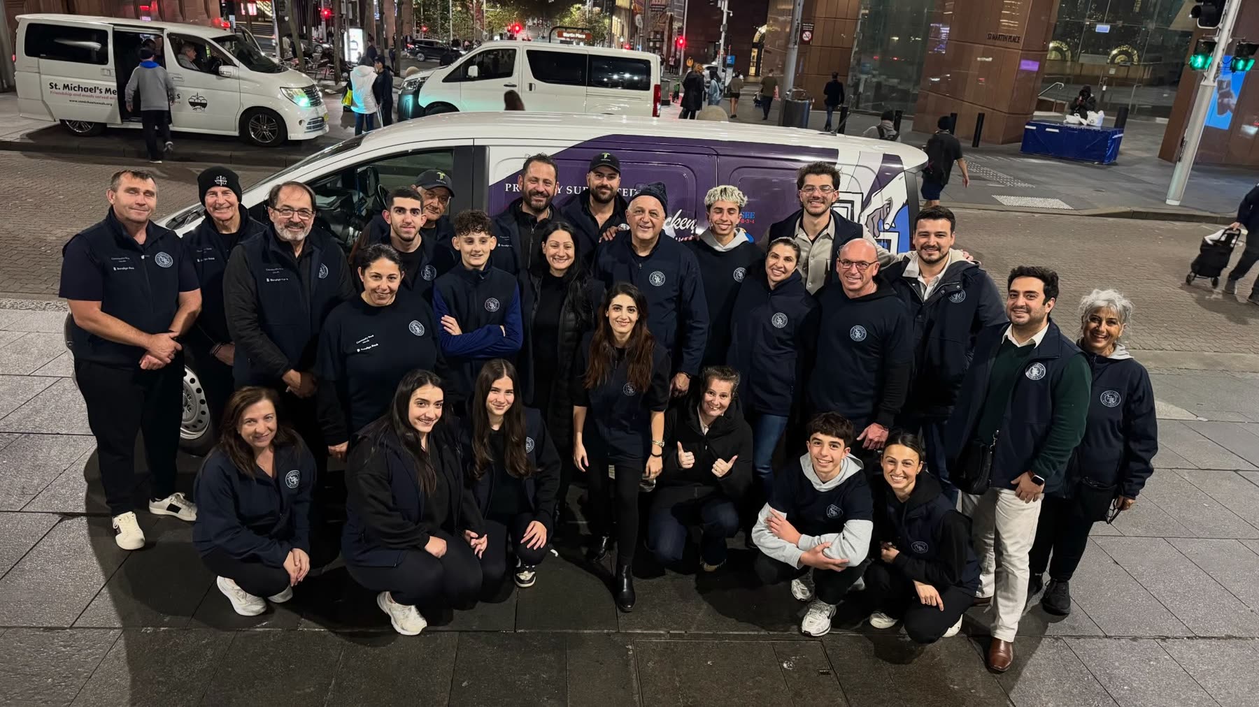 The A Touch of Kindness volunteers gathered in front of the van at Martin Place, Sydney, at night