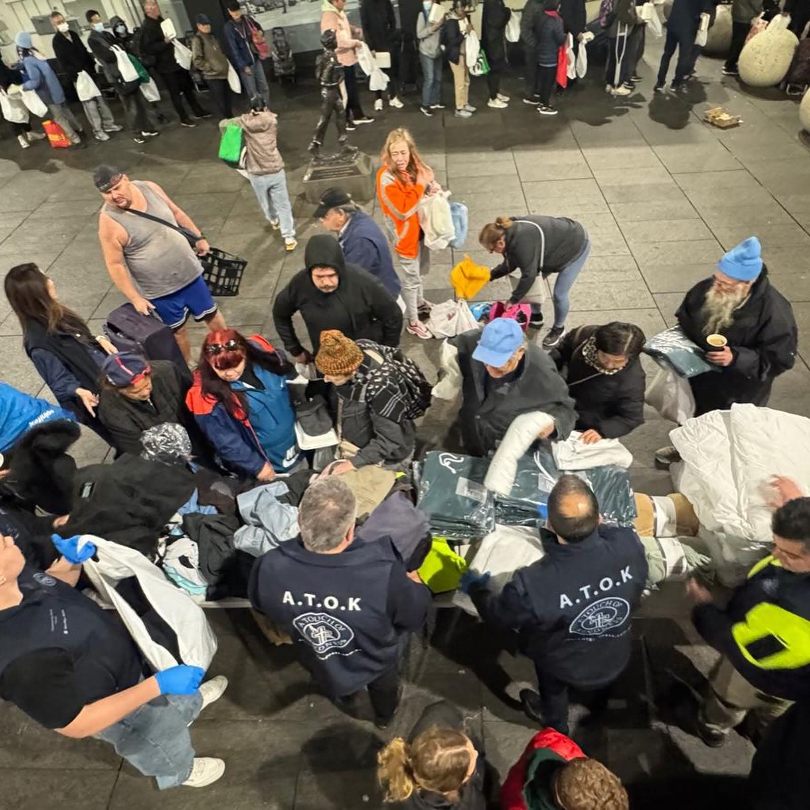 Volunteers and visitors gathered around the food and clothing on the ground at Martin Place, seen from above